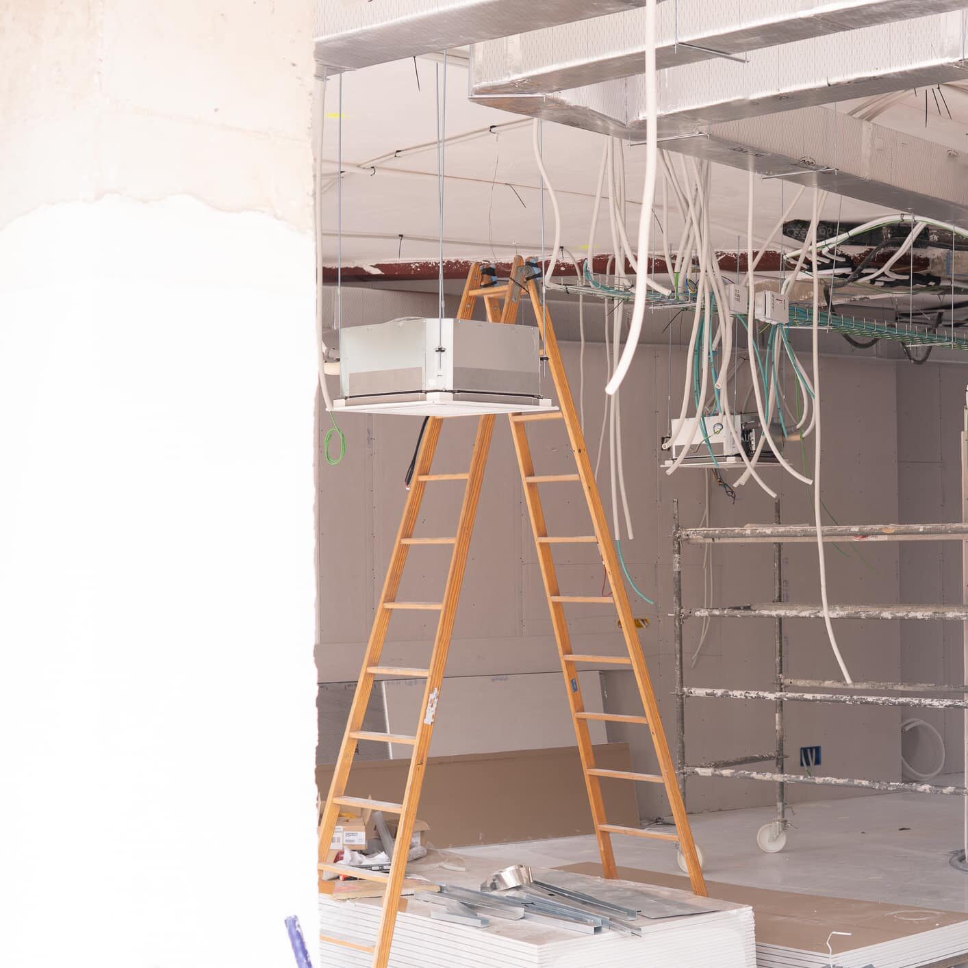 interior of a local in works of rehabilitation and conditioning with wiring stairs scaffolding air conditioning ducts. for business cafeteria. Concept construction and renovation company.