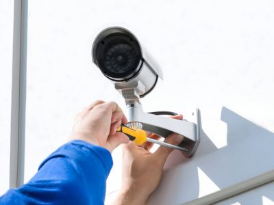 Technician Fixing Camera On Wall