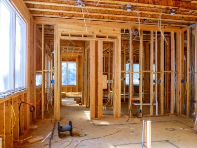 Worker installs electrical wires, insulation, and ceiling light before plasterboard